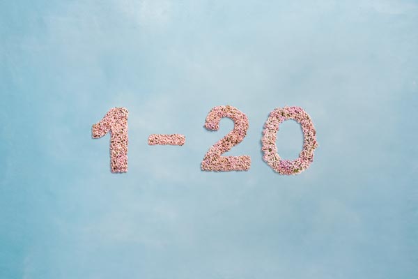 Tallene 1-20, skrevet med lyserøde blomster på lyseblå baggrund